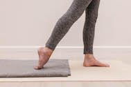 A pair of legs stretching the top of the right foot
